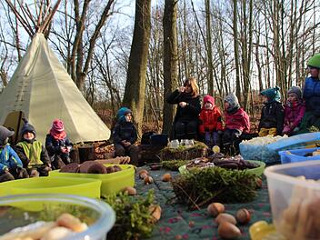Weihnachten nach Indianerart: Die Kinder des Waldkindergartens  Adelsdorf   sitzen  mit Erzieherin Claudia Smits   vor ihrem Tipi, singen und essen Plätzchen.  Foto: Christian Bauriedel
