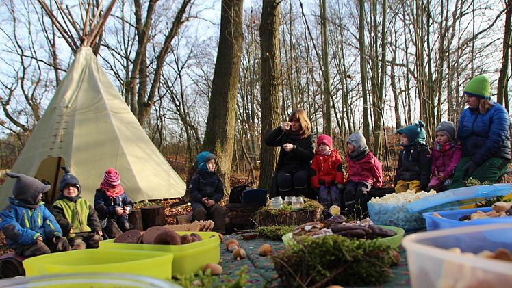 Weihnachten nach Indianerart: Die Kinder des Waldkindergartens  Adelsdorf   sitzen  mit Erzieherin Claudia Smits   vor ihrem Tipi, singen und essen Plätzchen.  Foto: Christian Bauriedel