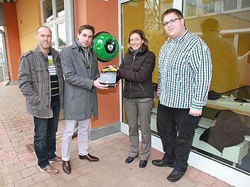 Geschäftsstellenleiterin Karin Kropfelder (2. v. r.) übergibt den Defibrillator an Bürgermeister Torsten Gunselmann (2. v. l.) und Konrektor Christian Scharting (l.). Rettungsassistent Andreas Reisch (rechts) machte vor Ort gleich die Einweisung. Foto: Mathias Erlwein