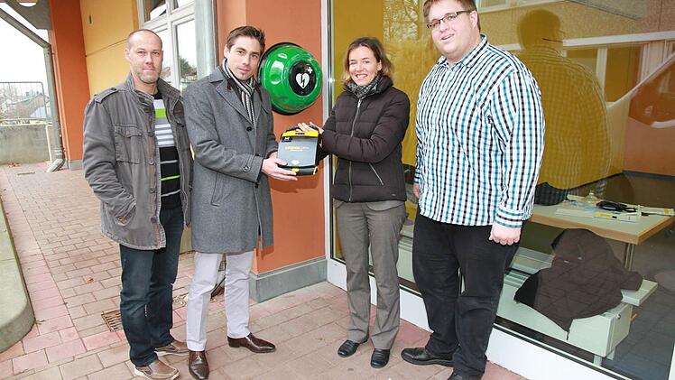 Geschäftsstellenleiterin Karin Kropfelder (2. v. r.) übergibt den Defibrillator an Bürgermeister Torsten Gunselmann (2. v. l.) und Konrektor Christian Scharting (l.). Rettungsassistent Andreas Reisch (rechts) machte vor Ort gleich die Einweisung. Foto: Mathias Erlwein