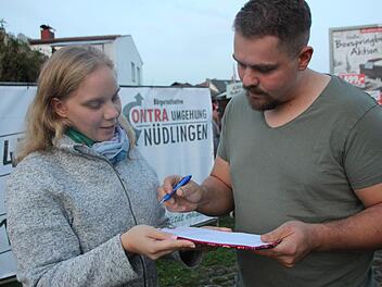 Jonathan Kaim unterschreibt die Liste für das Bürgerbegehren bei Christine Fell. Benedikt Borst