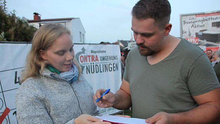 Jonathan Kaim unterschreibt die Liste für das Bürgerbegehren bei Christine Fell. Benedikt Borst