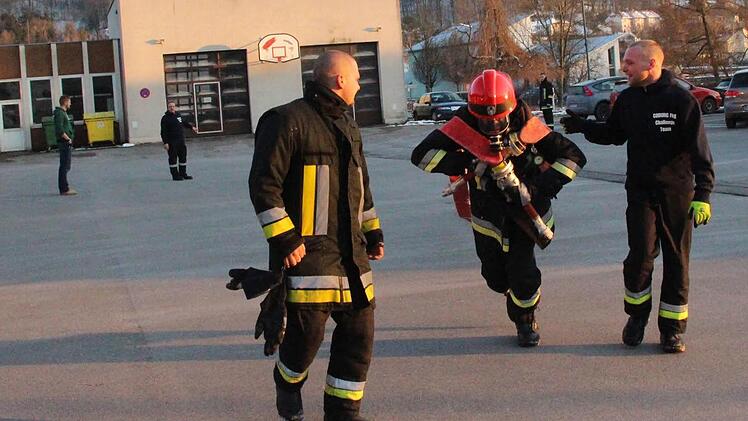 Je weiter die B-Schläuche gezogen werden, desto wärmer und schwerer werden sie. Sebastian Sauer (links) und Daniel Fritz (rechts) feuern hier Mike Korten an, der das Atemschutzgerät trägt und die Schläuche schleppt. Foto: Simone Bastian