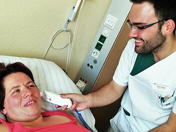 Julian Albert (19) misst bei Patientin Nicole Löbnitz die Temperatur. Sigismund von Dobschütz