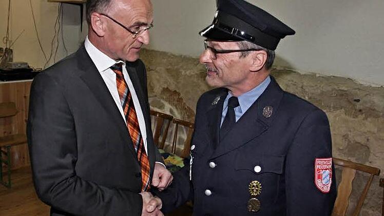 Karl-Ludwig Müller (rechts) nimmt einen dankbaren Händedruck von Landrat Wilhelm Schneider entgegen, der ihm das Ehrenzeichen der Feuerwehr für 40 Jahre aktiven Dienst verlieh.  Foto: Helmut Will
