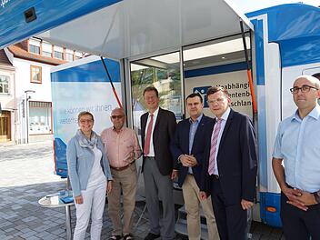 Das Beratungsmobil der UPD macht Station auf dem Viehmarkt. Ralf Brauksiepe (Dritter von links), Patientenbeauftragter der Bundesregierung, die Bundestagsabgeordnete Sabine Dittmar und Bürgermeister Armin Warmuth (Zweiter von rechts) besuchen den Stand. Foto: Guzy
