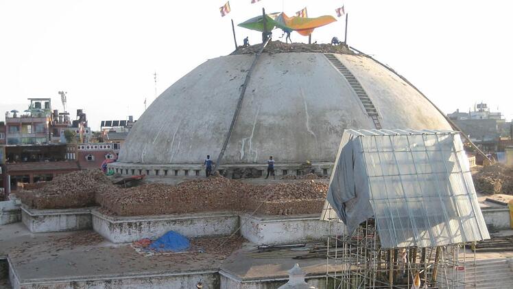Wie schon beim Einlegen einstürzender Gebäude wird auch beim Aufbau wenig auf Sicherheit geachtet. Unser Bild zeigt die Arbeiten an der großen Stupa von Bouddha (Weltkulturerbe). Jetzt fehlen die alles sehenden Augen des Buddha. Foto: Birgit Kirsch