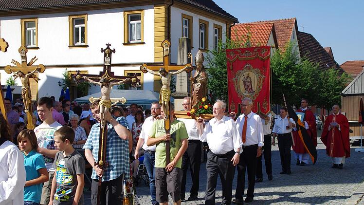In einer kleinen Prozession zogen die Träger der Kiliansfigur, die Fahnenabordnungen, die Ministranten und Pfarrer Georg Birkel und Gerhard Hellgeth zum Altar auf dem Kirchplatz.