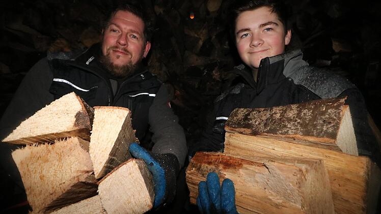 Im Regen und im Dunkeln haben Christian Neudecker und sein Sohn Florian noch am Donnerstag die ersten Holzscheite geschnitten. Foto: Ronald Heck