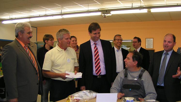 Geschäftsführer Wolfgang Badura erklärt beim Rundgang die Arbeiten in der Werkstatt. Im Bild von links Bürgermeister Gerhard Amon, Wolfgang Badura, Landrat Hermann Ulm, ein Lebenshilfe-Mitarbeiter und MdL Michael Hofmann Foto: Heidi Amon