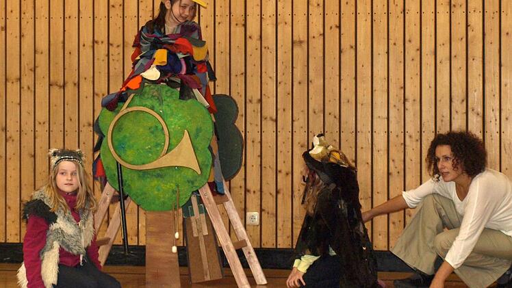 Die Katze (Alina Meyer, links) und der Wolf (Sophia Lorenz, rechts) lauern unter dem Baum, auf dem der Vogel (Kiara Lichter) sitzt. Ganz rechts Julia Ikodinovic.