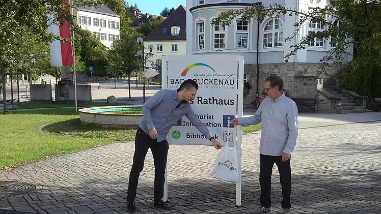 Einen fast schon legendären Ruf besitzt der Stoffbeutel, den Roland Heinlein (rechts) am Ende seines Berufslebens symbolisch an Kulturbüroleiter Jan Marberg (links) übergibt. Denn ohne die kleine Baumwolltasche mit allerlei interessanten Utensilien startete der künftige Ruheständler nie zu den Stadtführungen.Foto: Rolf Pralle