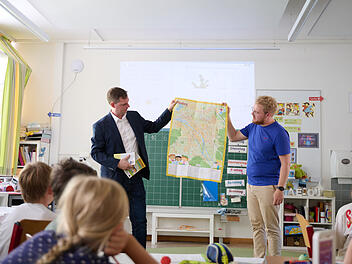 B&uuml;rgermeister Jonas Gl&uuml;senkamp (l.) und Maxi Manlig vom Stadtjugendring pr&auml;sentieren den Kinderstadtplan.