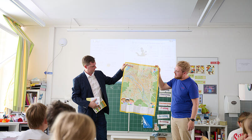 B&uuml;rgermeister Jonas Gl&uuml;senkamp (l.) und Maxi Manlig vom Stadtjugendring pr&auml;sentieren den Kinderstadtplan.
