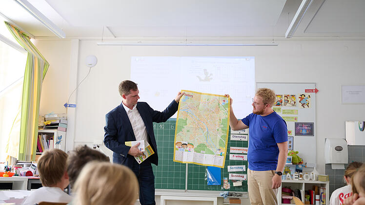 B&uuml;rgermeister Jonas Gl&uuml;senkamp (l.) und Maxi Manlig vom Stadtjugendring pr&auml;sentieren den Kinderstadtplan.