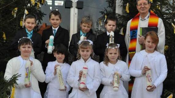 Pfarrweisach — Neun Kinder haben in der Pfarrkirche St. Kilian ihre Erstkommunion gefeiert vorne von links Paula Lurz und Amelie Bergner, beide Pfarrweisach, Luna Friedl, Neuses a. R., Jana Friedrich, Pfarrweisach, und Julia Vogler, Kraisdorf; dahinter Julian Bayersdorfer, Lohr, Elias Frank, Kraisdorf, Niklas Ruhnau, Pfarrweisach, und Kevin Burger, Ditterswind. Den Gottesdienst leitete Pater Alois Blüml (rechts).  Foto: Klemens Albert