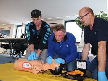 Unter Anleitung von Rettungsassistent Uve Bartz (rechts) üben Frank Keidel und Ulf Wagner an einer Puppe die Herz-Lungen-Wiederbelebung: 30 Mal drücken, dann zwei Atemstöße. Foto: Ralf Ruppert