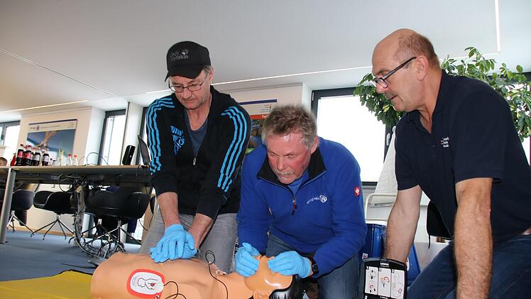 Unter Anleitung von Rettungsassistent Uve Bartz (rechts) üben Frank Keidel und Ulf Wagner an einer Puppe die Herz-Lungen-Wiederbelebung: 30 Mal drücken, dann zwei Atemstöße. Foto: Ralf Ruppert