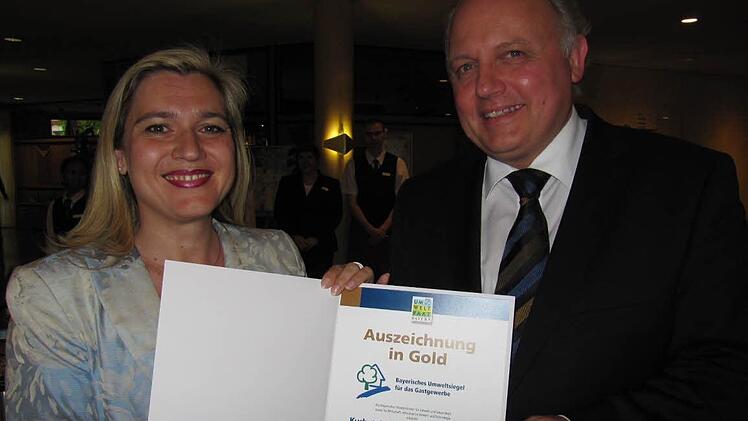Staatssekretärin Melanie Huml überreicht Geschäftsführer Andreas Poth die Urkunde zum Umweltsiegel in Gold