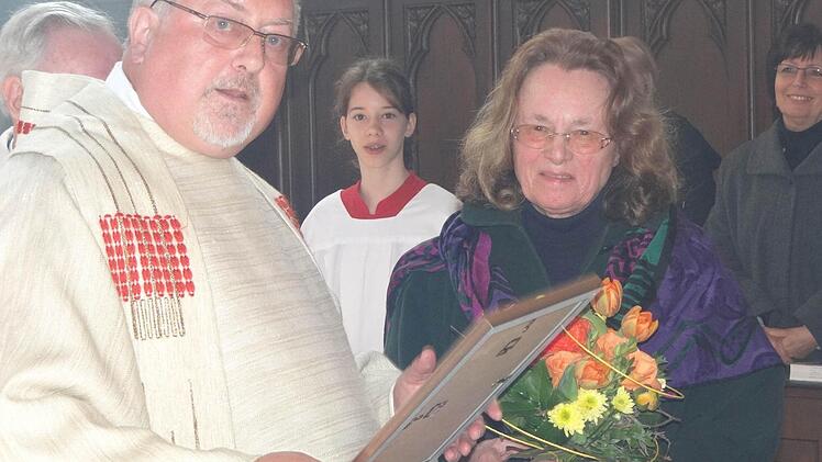 Rosemarie Bühler aus Ebern singt seit 59 Jahren im Kirchenchor. Für diesen treuen Dienst bedankt sich Pater Rudolf Theiler, stellvertretend für den Würzburger Bischof Friedhelm Hofmann.