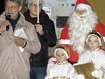 Bürgermeister Gerhard Wunder (l.) eröffnet zusammen mit dem Nikolaus und seinen beiden Engeln Lena (r.) und Julia das erste Adventsfenster am Rathaus. Zweiter von links Yannic Wildner. Foto: Susanne Deuerling