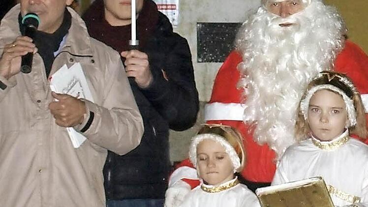 Bürgermeister Gerhard Wunder (l.) eröffnet zusammen mit dem Nikolaus und seinen beiden Engeln Lena (r.) und Julia das erste Adventsfenster am Rathaus. Zweiter von links Yannic Wildner. Foto: Susanne Deuerling