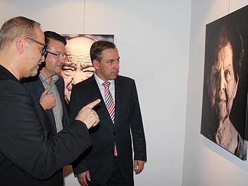 Christian Pöllmann erzählt Karsten Fischkal und Alexander Tritthart (v. l.), wie das Porträt der Adelsdorfer Ehrenbürgerin Gertraud Fröhlich entstanden ist. Foto: Johanna Blum