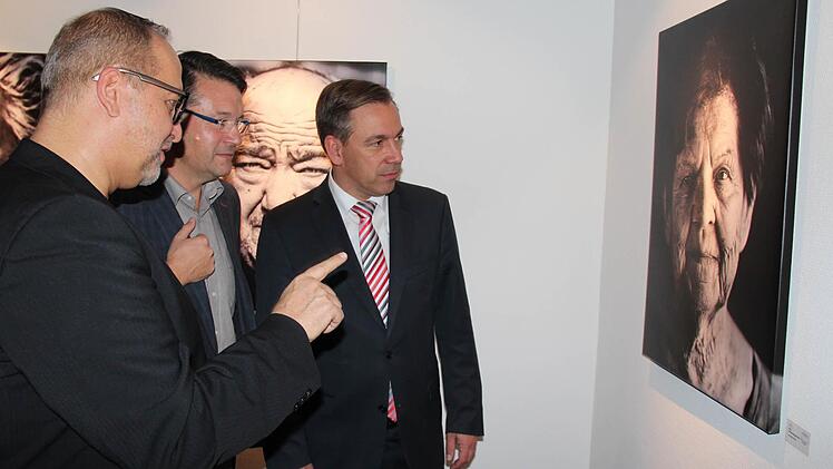 Christian Pöllmann erzählt Karsten Fischkal und Alexander Tritthart (v. l.), wie das Porträt der Adelsdorfer Ehrenbürgerin Gertraud Fröhlich entstanden ist. Foto: Johanna Blum