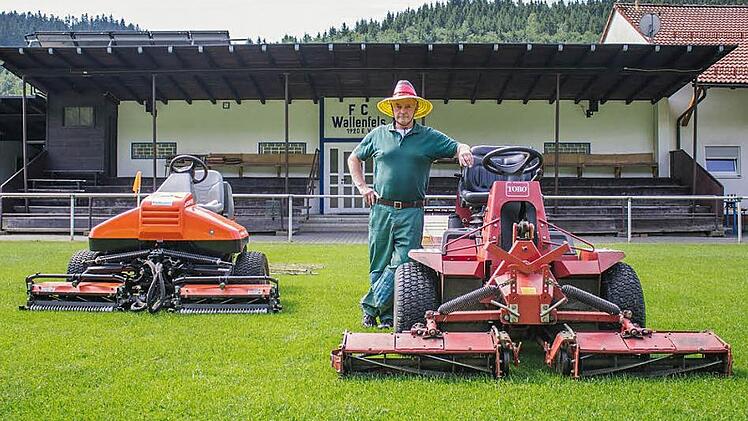 Nur echt mit Hut: Die schwarz-rot-goldene Kopfbedeckung gehört für Georg Heibl dazu, wenn er mit seinen Traktoren den Rasen auf die passende Länge bringt. Auf vier Zentimeter ist der 17 000 Euro teure linke Rasenmäher während der Saison eingestellt. Foto: Marian Hamacher