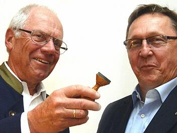 Nicht den Stab, sondern den Dienststempel übergab nach 34-jähriger Tätigkeit als Alpenvereinsvorsitzender Heinz Steidle an seinen Nachfolger Eisenmann. Foto: Peter Rauch