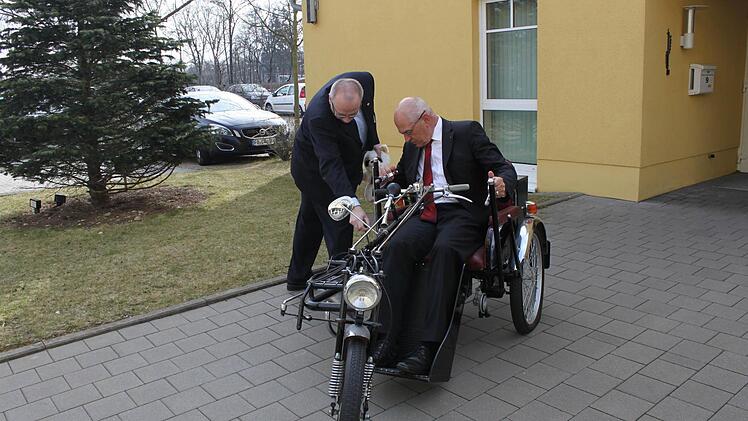 Was aussieht wie ein Trike, ist ein altes Fortbewegungsmittel für Behinderte. Günther Denzler lässt es sich von Wolfgang Caps erklären. Foto: Carmen Schwind
