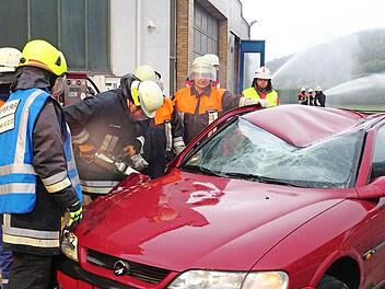 Konzentriert arbeiten die Feuerwehrleute mit dem Rettungsspreizer an dem Unfallauto. Foto: Feuerwehr