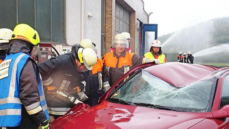Konzentriert arbeiten die Feuerwehrleute mit dem Rettungsspreizer an dem Unfallauto. Foto: Feuerwehr