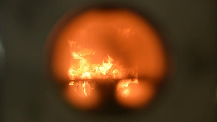 Wer durch das kleine runde Guckloch des Ofens blickt, sieht fast nur Flammen. Foto: Ronald Rinklef
