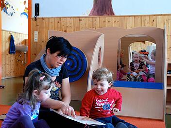 Im Kindergarten Steinach liest Kinderpflegerin Agnes Tuschinski Nora und Bastian aus einem Buch vor, während sich im Hintergrund  Eva, Dana und Henriette (von links)  gegenseitig frisieren.  Archivfoto: Kathrin Kupka-Hahn