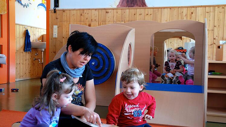 Im Kindergarten Steinach liest Kinderpflegerin Agnes Tuschinski Nora und Bastian aus einem Buch vor, während sich im Hintergrund  Eva, Dana und Henriette (von links)  gegenseitig frisieren.  Archivfoto: Kathrin Kupka-Hahn