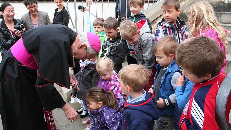 Der Erzbischof zeigt den Kindergartenkindern sein Kreuz Foto: Evi Seeger