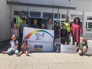 Rektorin Sabine Kreil (rechts) und die Schulkinder können einen Scheck von 2222,22 Euro an den Verein "Bad Brückenau hilft" überreichen. Christian Wirth (link) und Dirk Stumpe vom Brückenauer Hilfsprojekt freuen sich darüber.