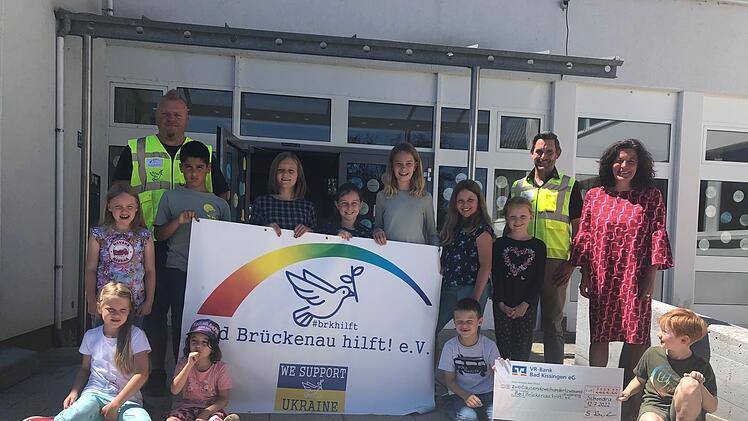 Rektorin Sabine Kreil (rechts) und die Schulkinder können einen Scheck von 2222,22 Euro an den Verein "Bad Brückenau hilft" überreichen. Christian Wirth (link) und Dirk Stumpe vom Brückenauer Hilfsprojekt freuen sich darüber.