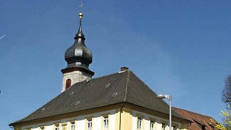 Das heutige Pfarrhaus in Prölsdorf hatte 1705 der Fürstbischof von Greifenklau als Amtsgebäude errichtet. Es zeugt bis heute von der wechselvollen Geschichte des Marktes Prölsdorf. Der Ort war einst Sitz eines Landgerichts. Hinter dem Pfarrhaus ist der Turm der Kirche Sankt Sebastian zu sehen, die 1766 neu erbaut wurde. Fotos: Sabine Weinbeer