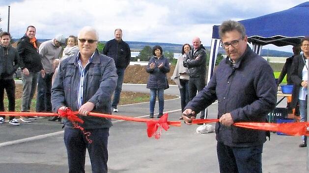 Gleich ist das Schleifchenband durchschnitten und die Straße Am Hahnberg frei für den Verkehr. An den Scheren (von links): Markus Rützel (Baufirma), Ulrich Kühnel (Planung) und Rolf Rosenbauer.  Foto: Norbert Karbach