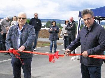 Gleich ist das Schleifchenband durchschnitten und die Stra&szlig;e Am Hahnberg frei f&uuml;r den Verkehr. An den Scheren (von links): Markus R&uuml;tzel (Baufirma), Ulrich K&uuml;hnel (Planung) und Rolf Rosenbauer.  Foto: Norbert Karbach