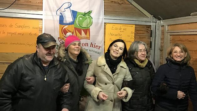 Fr&ouml;hliche Stimmung herrschte im Stand von "Nat&uuml;rlich von hier" (von links): Oliver Ulrich, Elke Friedsam, Karin Fesser, Ingrid F&auml;cher und die Pr&auml;sidentin des Departements, Marie-Pierre Mouton, schunkeln zu Musik des Sander Blasorchesters.Monika G&ouml;hr /Freundeskreis Ha&szlig;berge-Tricastin