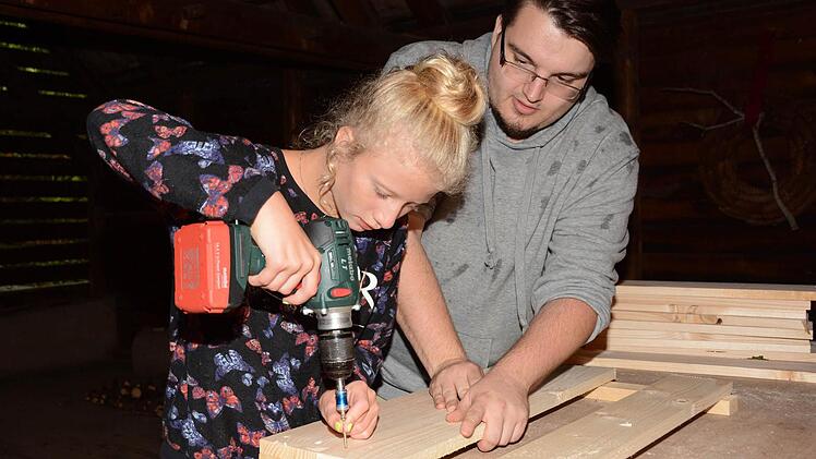 Tatjana lernt von Thomas Schneider, wie man Holzverkleidungen für Pflanzkübel ganz einfach selbst bauen kann. Foto: Dagmar Besand
