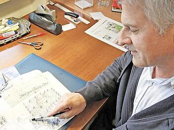 Hans Schaub beugt sich über die historische Jagdkarte mit dem Kreuzberg aus dem Jahr 1740.  Foto: Mathias Erllwin