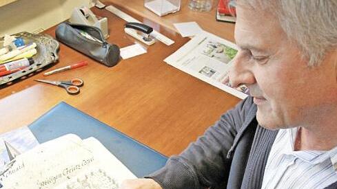 Hans Schaub beugt sich über die historische Jagdkarte mit dem Kreuzberg aus dem Jahr 1740.  Foto: Mathias Erllwin