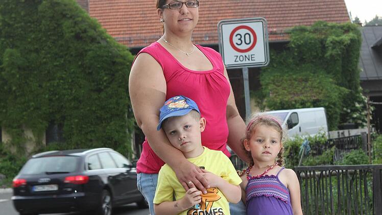 Andrea Schramm und ihre Kinder Yannik und Sophia hoffen, dass die Autos in Zukunft langsamer durch Stockheim fahren. Foto: Jan Koch