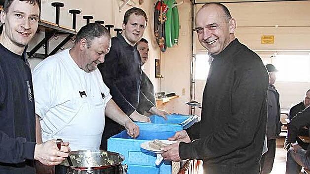 Hausmetzger Ottmar Schmidt (Zweiter von links) f&uuml;llt die Teller. Auch B&uuml;rgermeister Heinrich S&uuml;&szlig; lie&szlig; es sich schmecken.  Foto: Richard S&auml;nger