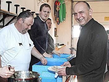 Hausmetzger Ottmar Schmidt (Zweiter von links) füllt die Teller. Auch Bürgermeister Heinrich Süß ließ es sich schmecken.  Foto: Richard Sänger