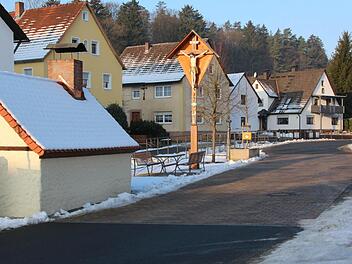 Im Zuge der Dorferneuerung in Rüssenbach wurde beim Backofen neben dem Kreuz ein Aufenthaltsbereich geschaffen und die Straße gepflastert. Dank fehlender Ausbau-Beitragssatzung mussten sich die Anlieger an den Kosten nicht beteiligen. Foto: Josef Hofbauer